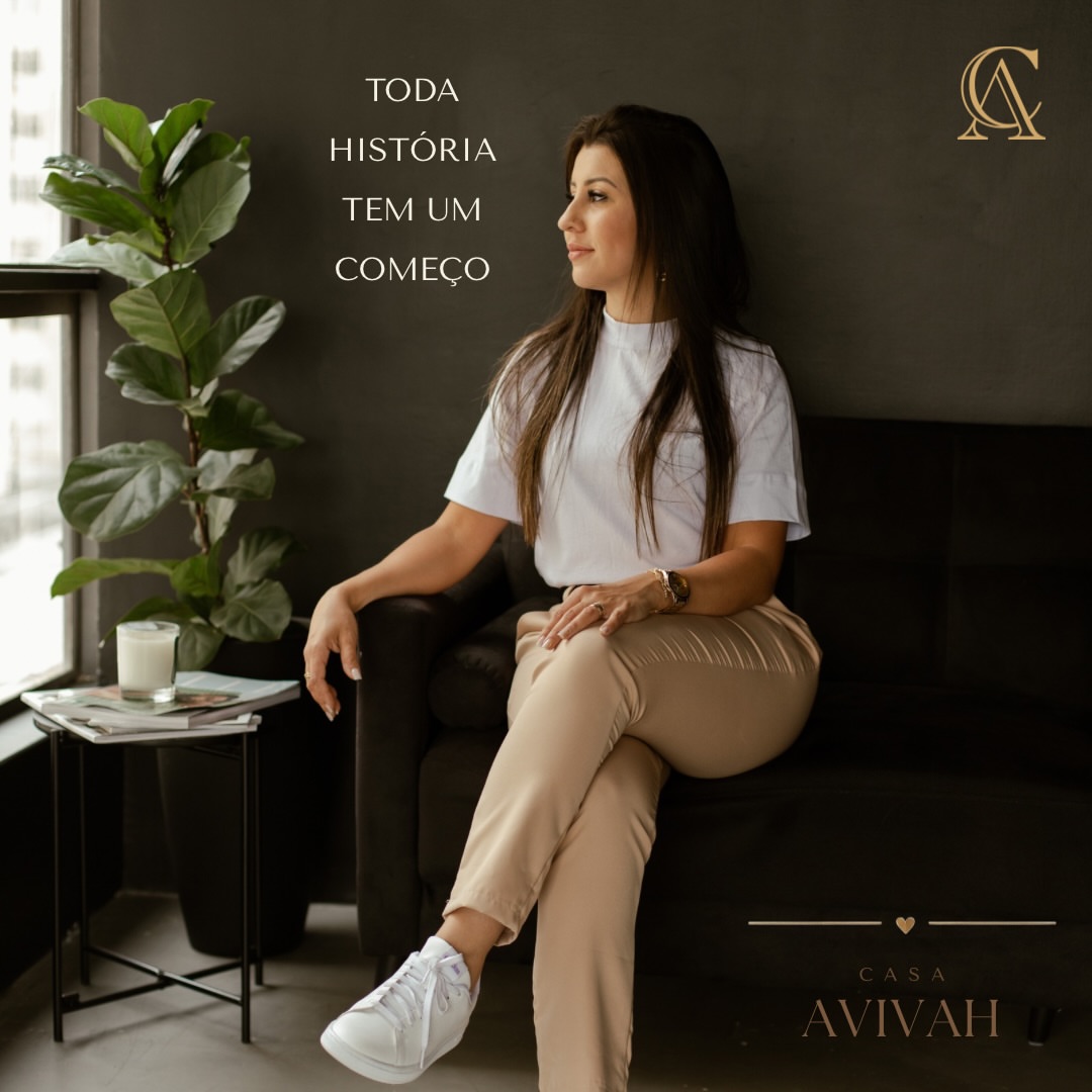 A dona da Casa Avivah sentada em uma sala, junto a uma janela e uma planta