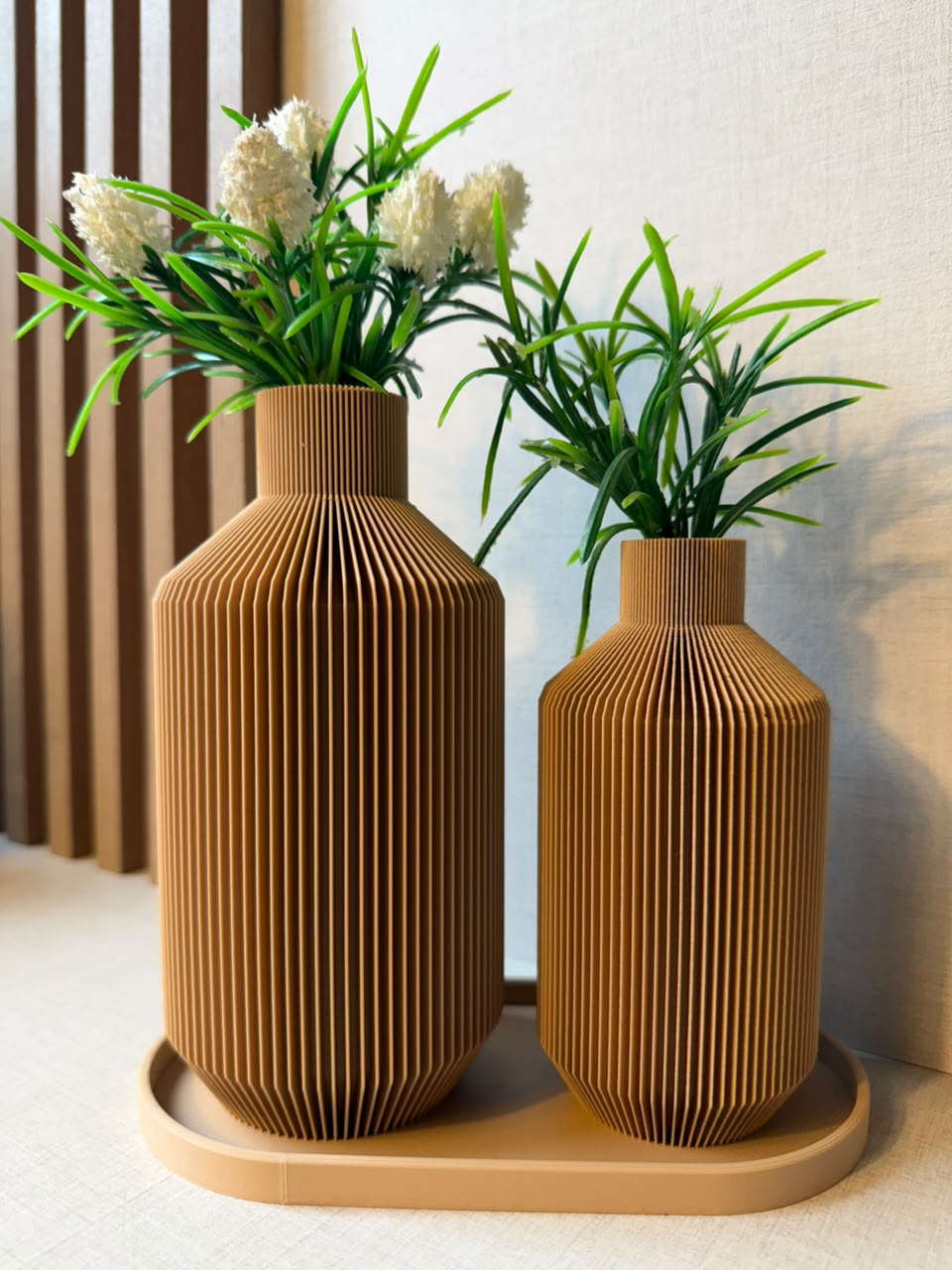 Dois vasos decorativos canelados com flores e folhagens